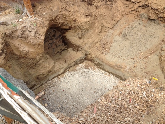 The hole in the ground is now ready for the vault and to drill holes into the building for the pipes to come from the new water line into the building.